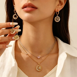 Detalle de un conjunto de joyas árbol de la vida y sol luna con incrustaciones de nácar.