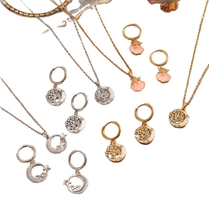 Conjuntos de joyas Árbol de la Vida y concha con collares y pendientes de aro en oro y plata.