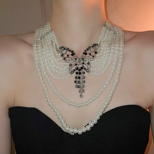 Élégant collier de perles multi-rangs avec un pendentif papillon en strass brillant.