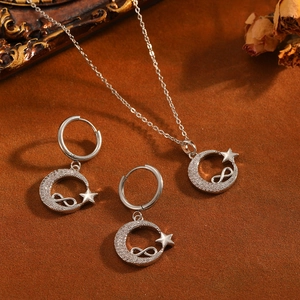 Vista detallada de conjunto de joyas de acero con estrella y luna y piedras brillantes