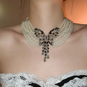 Élégant collier de perles multicouches avec pendentif papillon en strass porté