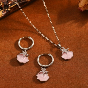 Detalle elegante del conjunto de collar y pendientes con colgante de estrella rosa
