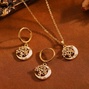Detalle del conjunto de joyas de acero dorado con el árbol de la vida y la luna.