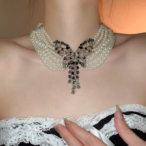 Collier de perles multi-rangs élégant avec pendentif papillon en strass étincelant.