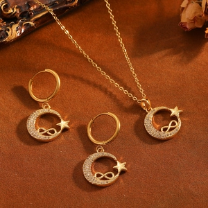 Detalle del conjunto de joyas de luna y estrella doradas con cristales brillantes.