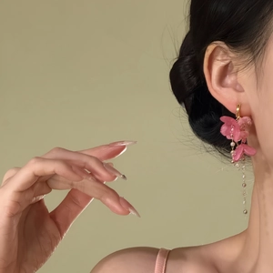 Detailansicht eleganter rosa Blumen-Quasten-Ohrringe an einem asiatischen Modell.