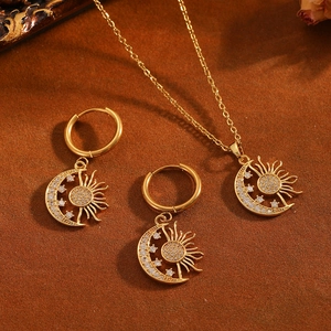 Vista detallada del conjunto de collar y pendientes de sol y luna dorados con circonitas