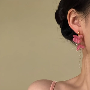 Nahaufnahme der rosa Blüten-Ohrringe mit Quasten, getragen am Ohr für einen süßen Look