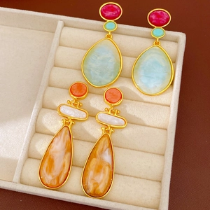 Close-up view of vintage resin drop earrings with marble and colorful stone inlay