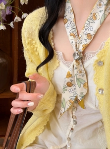 Detailed view of a floral silk scarf necklace with an adjustable metallic slider bead.