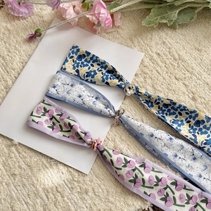 Close-up of three skinny floral silk scarf necklaces with adjustable slides