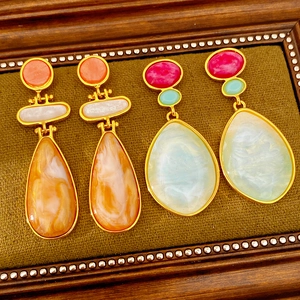 Detailed macro view of vintage resin teardrop earrings with elegant marble textures and gold trim