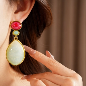 Macro view of vintage-style resin teardrop earrings with elegant gold-tone setting