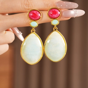 Detailed macro view of vintage resin drop earrings with red, green and white waterdrop pendants