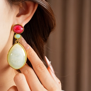 Close-up shot of vintage resin drop earrings with gold-tone accents on a model's ear