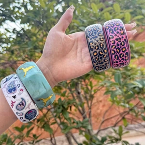Gros plan de bracelets larges de style Y2K avec imprimé léopard et motifs paisley