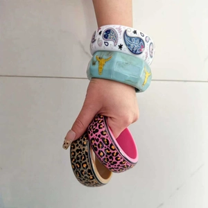 Gros plan de larges bracelets de style Y2K avec imprimés léopard et motifs de cachemire