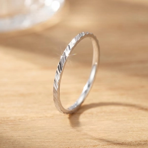 Detailed macro view of minimalist stainless steel ring with elegant faceted textures
