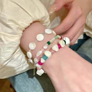Primer plano de pulseras de cuentas de estilo dopamina con conchas irregulares