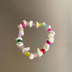 Primer plano detallado de una pulsera estilo dopamina con cuentas de concha blanca