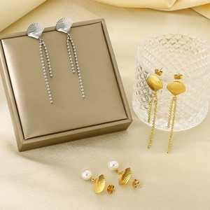 Detail view of gold and silver stainless steel shell earrings with pearls and tassels.