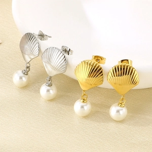Detail of shell-shaped stainless steel earrings with white pearl drops in gold and silver.