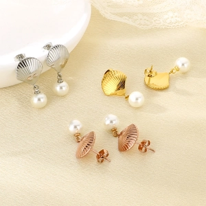 Detail of stainless steel shell earrings with pearls in gold, silver, and rose gold finish.
