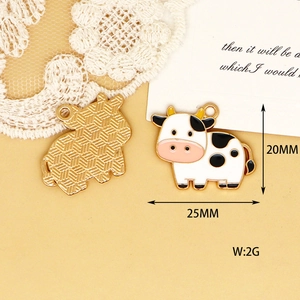 Macro detail of cartoon cow alloy enamel pendant for DIY jewelry, showing 25mm size