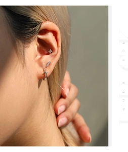 Detalle del pendiente de plata S925 moissanita y aro con cruz en oreja de modelo