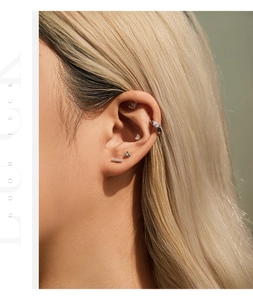 Primer plano de pendientes minimalistas de plata S925 con moissanita usados en el cartílago