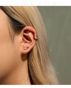 Primer plano de pendiente lineal de plata S925 con moissanita en la oreja del modelo