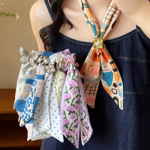 Gros plan d'un collier écharpe en soie avec imprimés tulipes colorées et breloques en perles