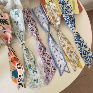 Détail de plusieurs écharpes étroites à fleurs colorées avec bagues décoratives