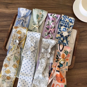 Collection de foulards étroits à fleurs et à pois avec des curseurs décoratifs en métal et perles.