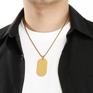 Gold stainless steel dog tag necklace shown on a male model for a minimalist street style.