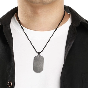 Detail of a minimalist stainless steel dog tag necklace with a black bead chain on a model.