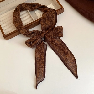 Elegant vintage brown paisley print skinny silk scarf for women tied in a chic bow