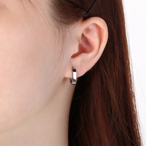 Close-up of a minimalist silver stainless steel U-shaped square hoop earring on ear