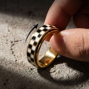 Primer plano de un anillo giratorio de acero inoxidable con banda de tablero de ajedrez