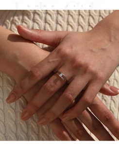 Close-up of a minimalist silver double-layer ring with a pear-shaped moissanite