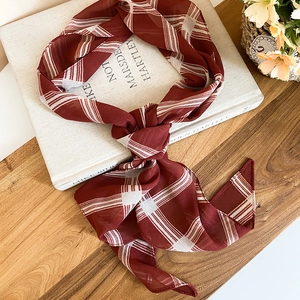 Vintage red and white striped silk scarf tied in a stylish knot for a chic summer look