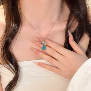 Vista dettagliata della collana estiva con stella marina e perla su un collo femminile