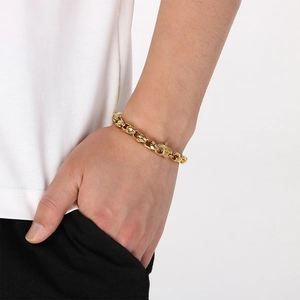 Close-up detail of a vintage gold stainless steel corn chain bracelet on a man's wrist.