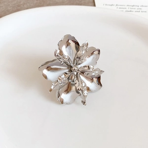 Primo piano dettagliato di un anello a fiore in metallo argento con finitura lucida
