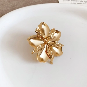 Primo piano di un elegante anello a fiore dorato con petali testurizzati