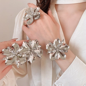 Dettaglio di un grande set di gioielli floreali metallici con anello e bracciale