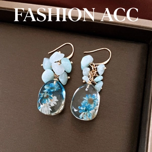 Handmade resin teardrop earrings with blue dried flowers and stone beads.