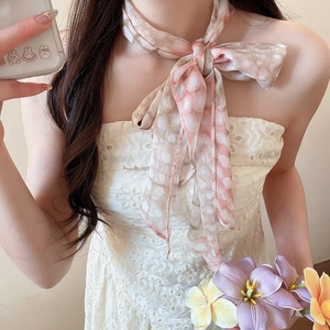 Detailed view of the pink floral print silk scarf necklace tied in a bow