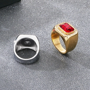 Detail view of gold and silver hip-hop men's rings featuring a large red gemstone.