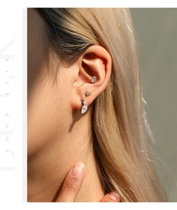 Primer plano de pendientes minimalistas de plata de ley 925 con moissanita en la oreja modelo